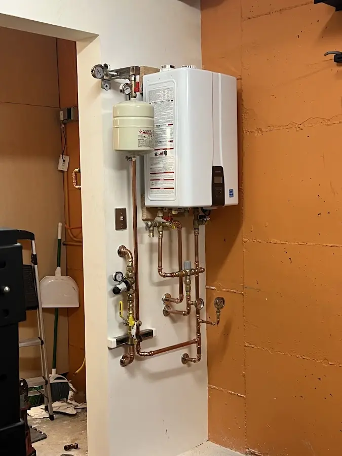 Plumbing technician inspecting water heater connections in Ives Estates
